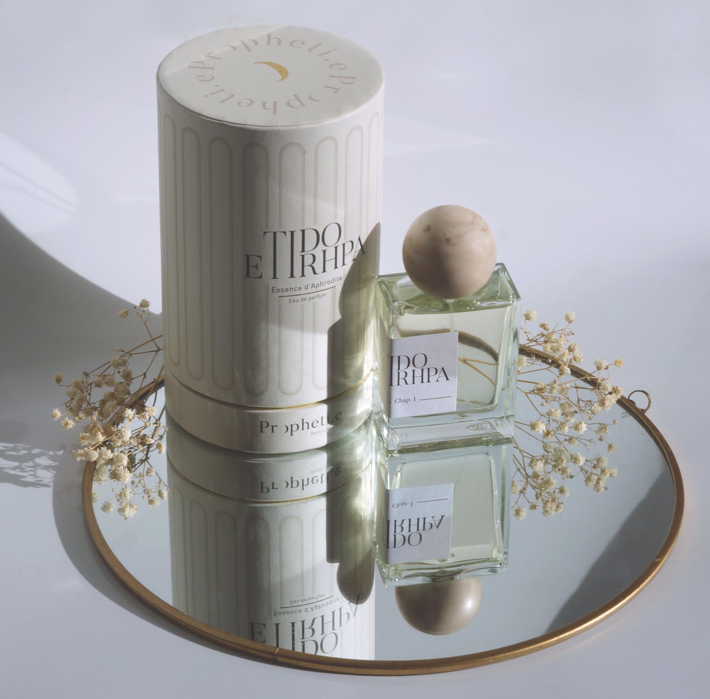 Coffret Etidorhpa avec le parfum à côté posé sur un miroir avec des fleurs séchées - Vue de dessus