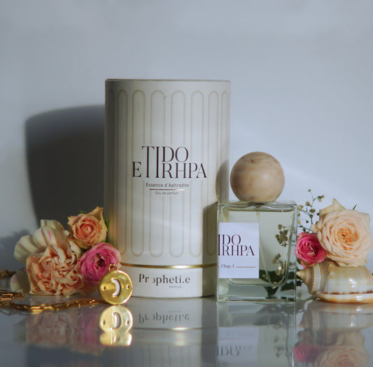 Coffret Anehta avec le parfum à côté avec des roses rose et quelques fleurs coquillages + le bijou face Lune - Vue de face