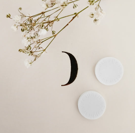 2 pierres Propheti.e sur un miroir et quelques fleurs séchées.