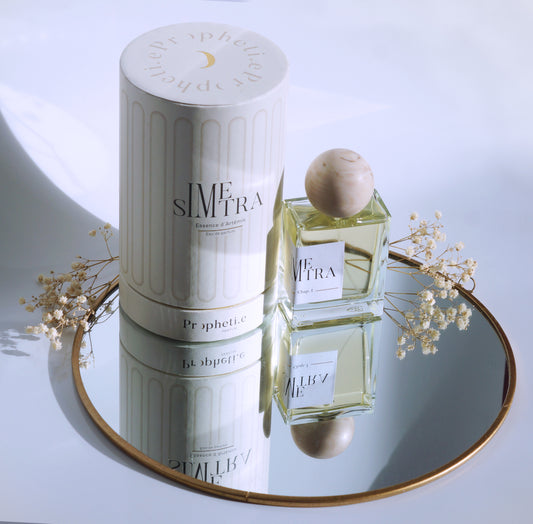 Coffret Simetra avec le parfum à côté posé sur un miroir avec des fleurs séchées - Vue de dessus