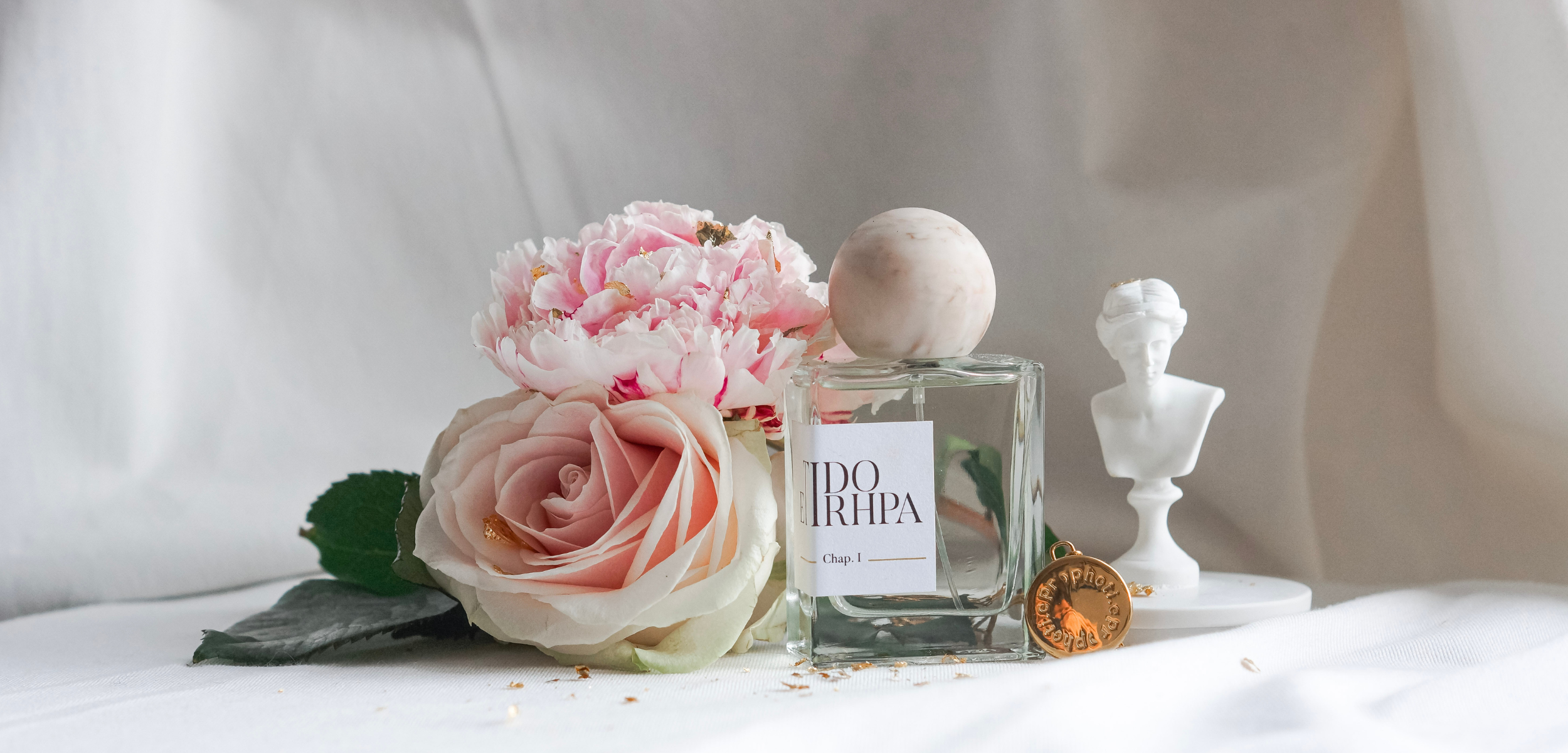 Flacon du parfum ETIDORHPA Aphrodite avec le médaillon, des fleurs et une statue buste de femme