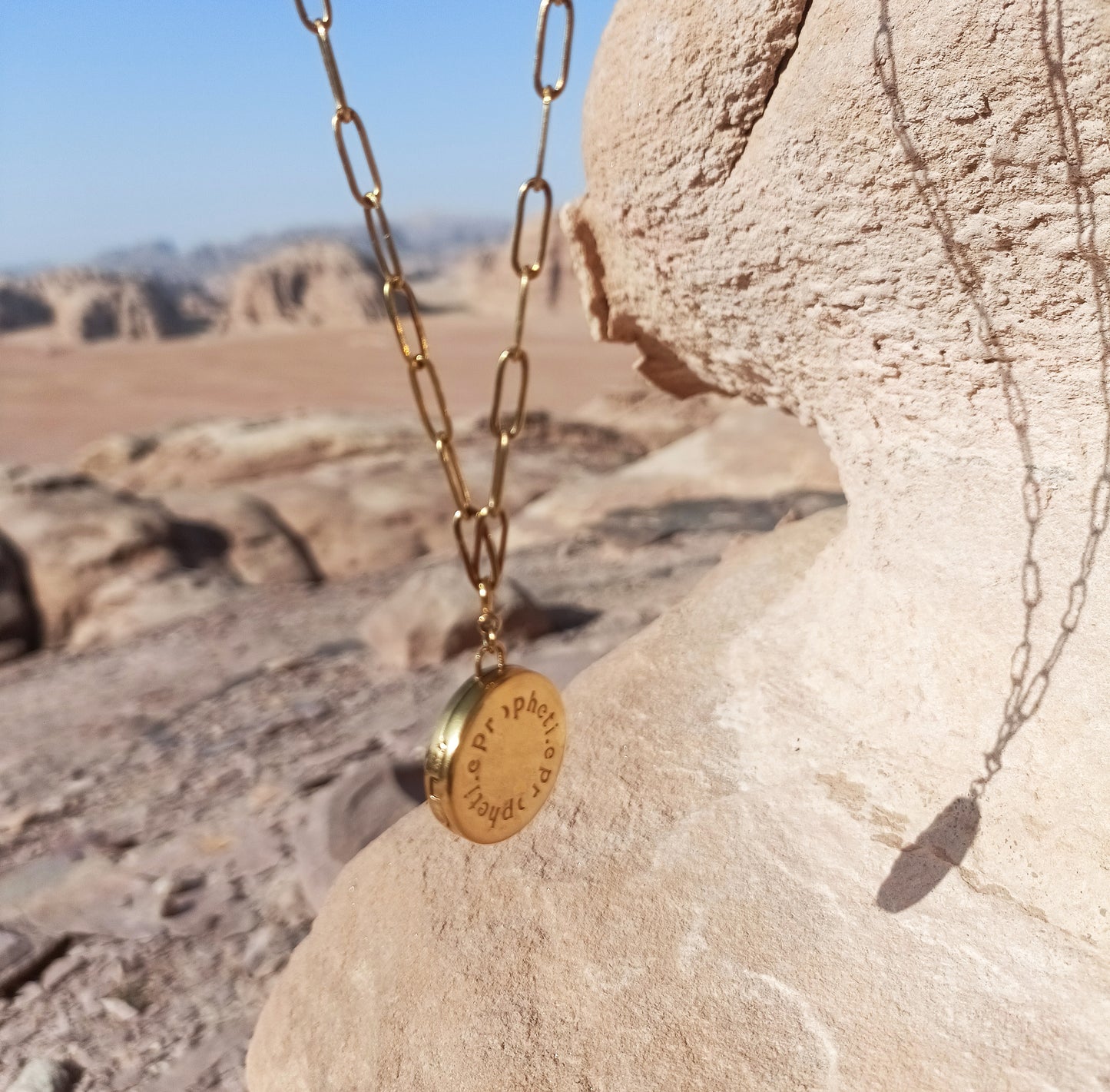 Le bijou Lune Propheti.e côté Propheti.e suspendu avec en fond le desert.